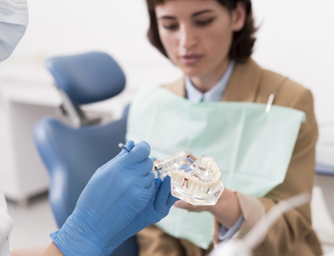 female-patient-looking-dental-mold-with-orthodontist Implants dentaires à Rabat: retrouver ses dents perdues grâce à une solution fiable et durable